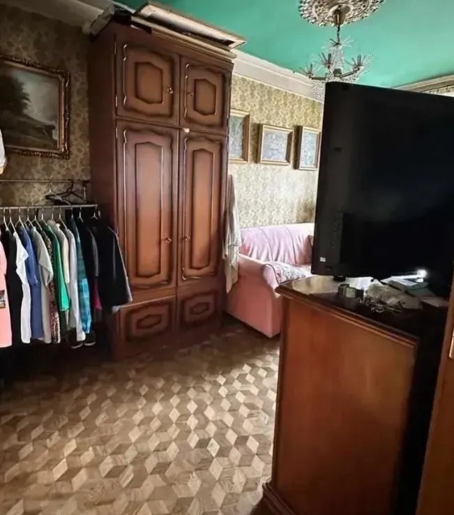 Salon z ogłoszenia: ciemny kadr, wieszak z ubraniami