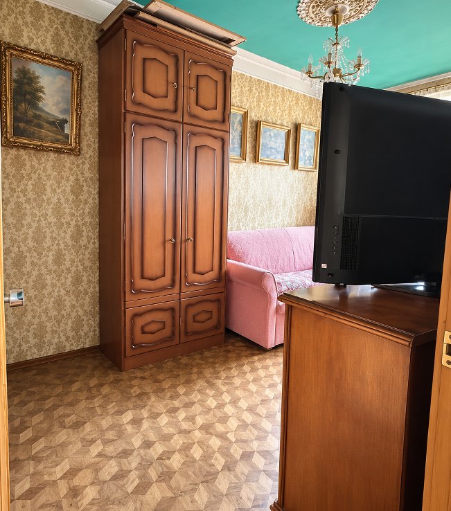 Ten sam salon po retuszu: jasno, bez ubrań, te same meble